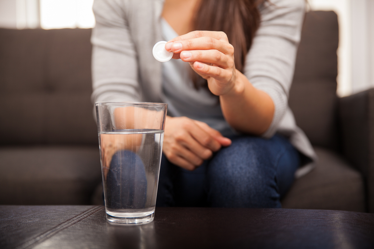 lady dropping tablet in water