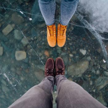 Two pairs of feet in boots