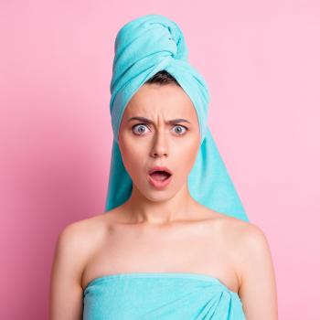 woman looking shocked in a towel